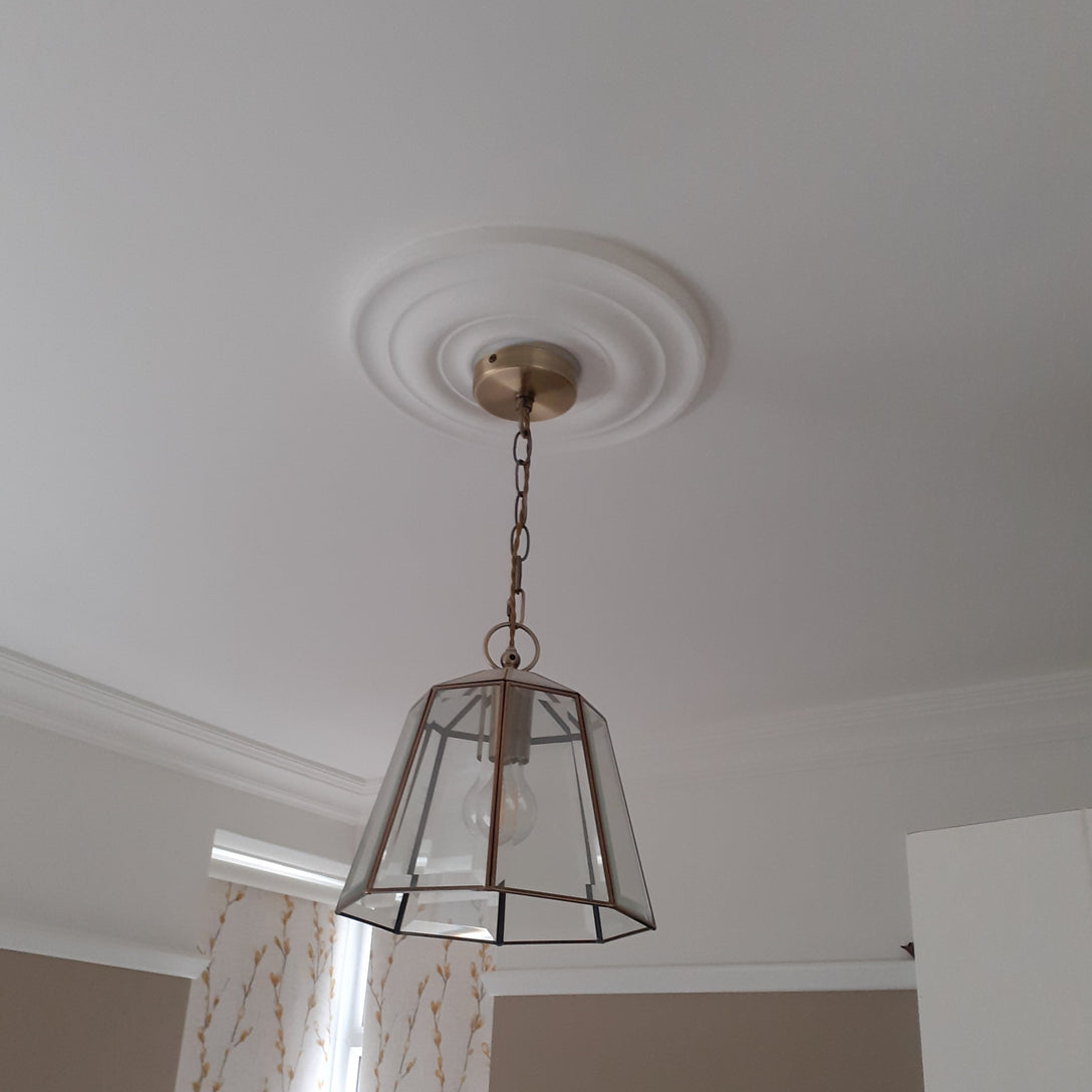 small plaster ceiling rose in white room