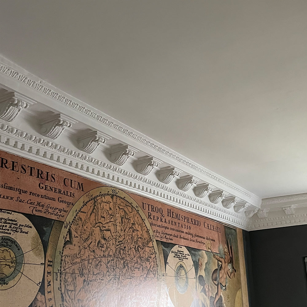 victorian plaster coving fitted in wallpapered room 