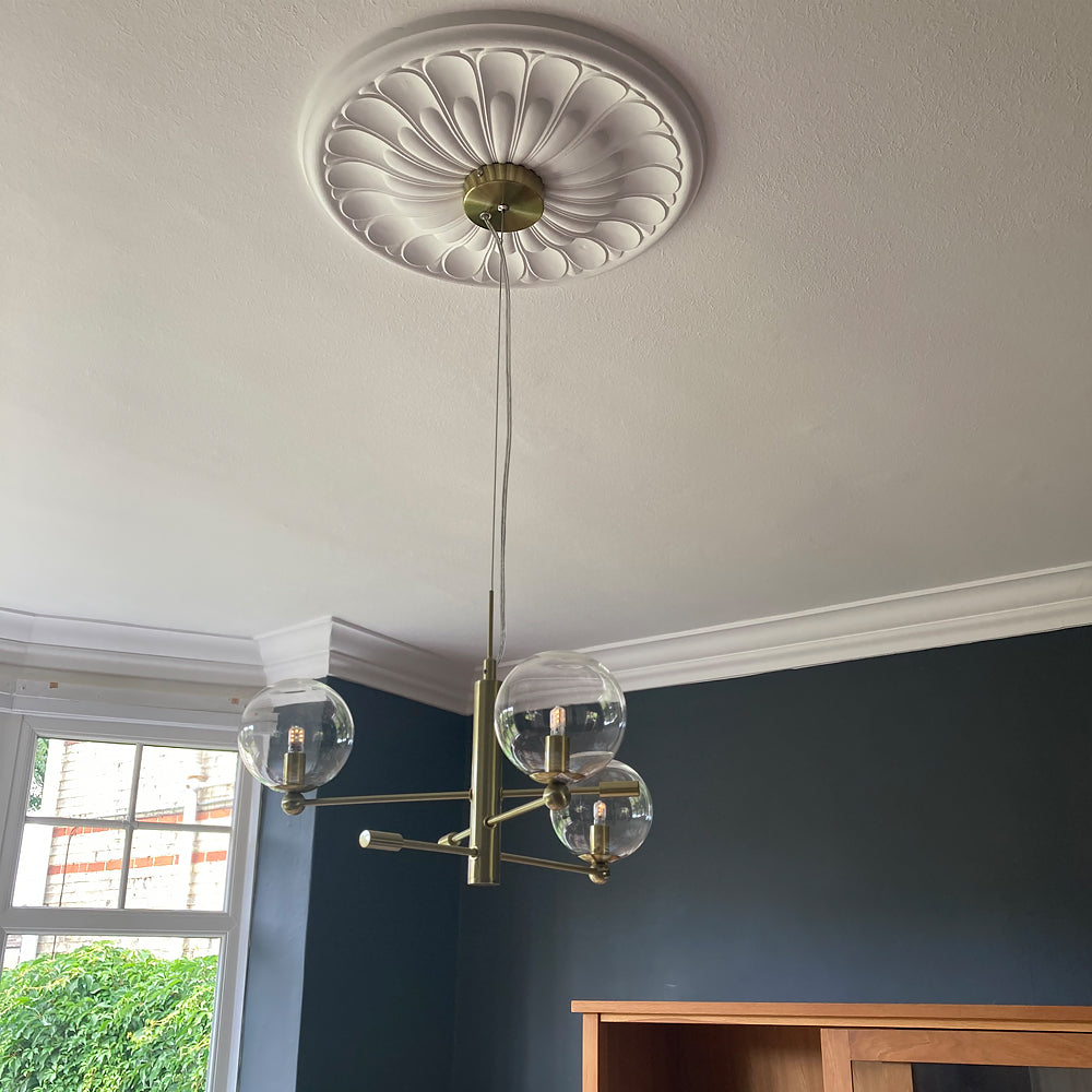 art deco plaster ceiling rose fitted in blue room with chandelier