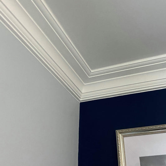 Section of Plaster Coving shown against a blue wall  - 110mm Drop