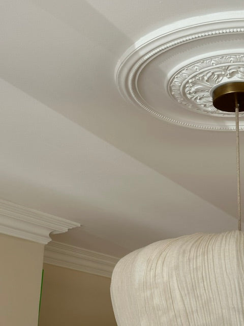 Close up victorian ceiling rose and coving fitted in living room