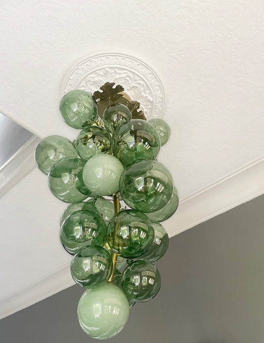 close up green light fitting with victorian ornate ceiling rose