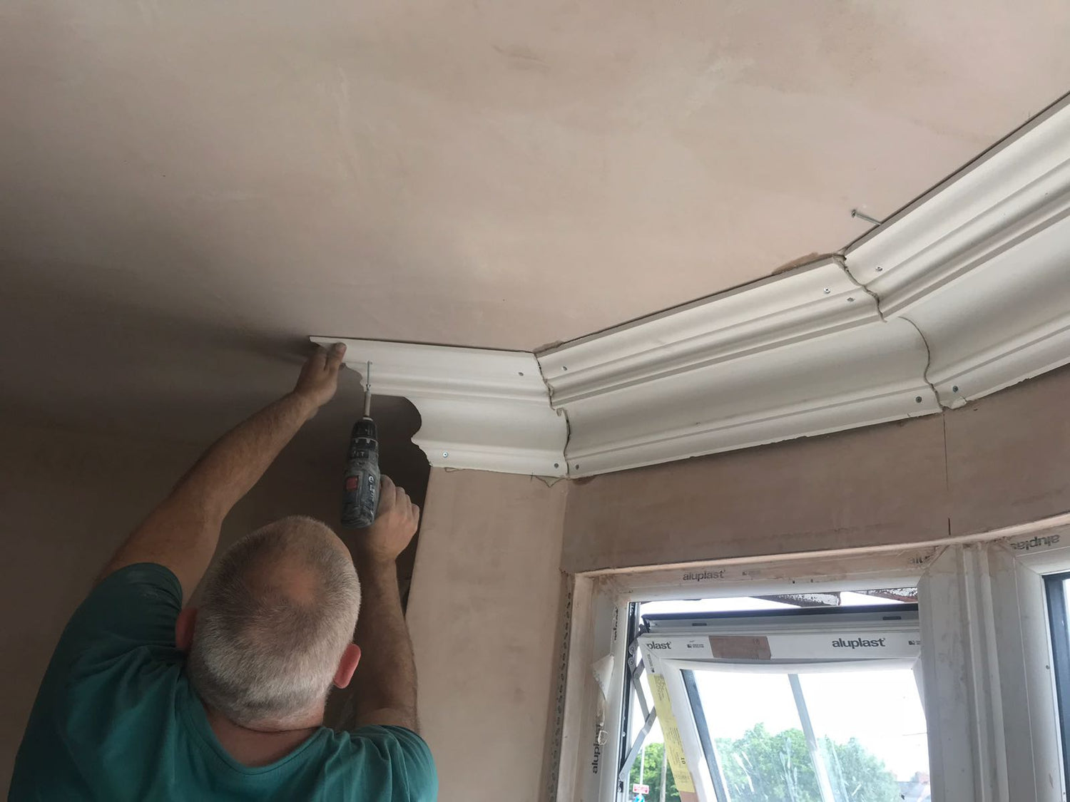 Large swan neck plaster coving being fitted