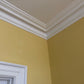 Victorian Swan Neck coving against yellow wall