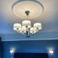 adams sunburst plaster ceiling rose shown in a blue bedroom