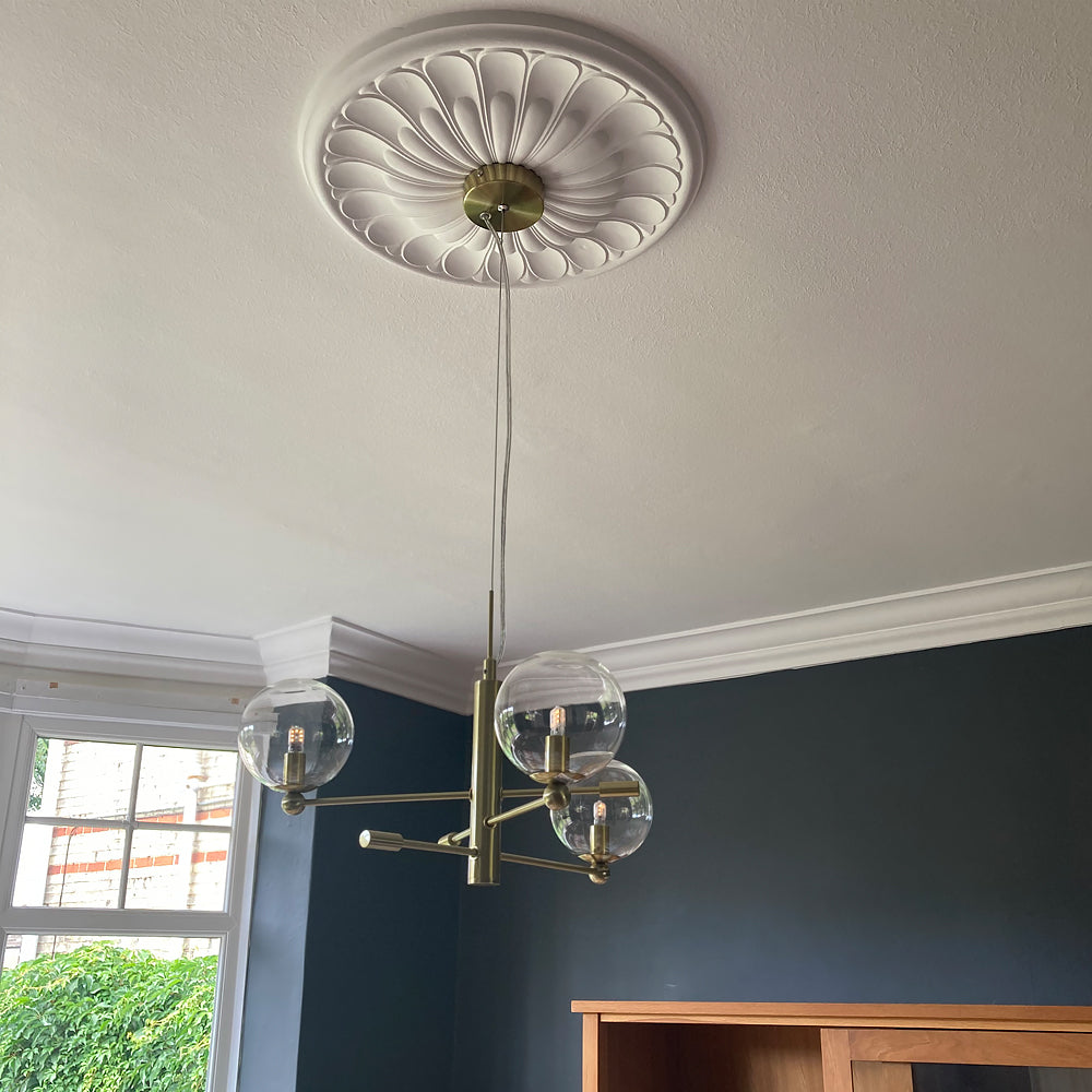 art deco plaster ceiling rose fitted in blue room with chandelier 