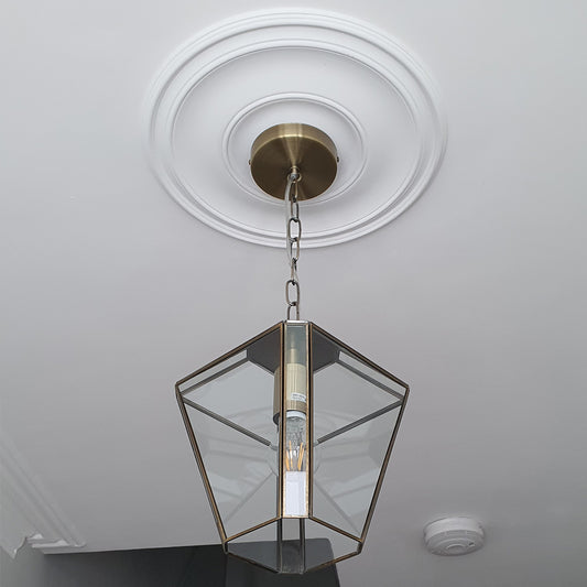 plain spun plaster ceiling rose shown with a chandelier 